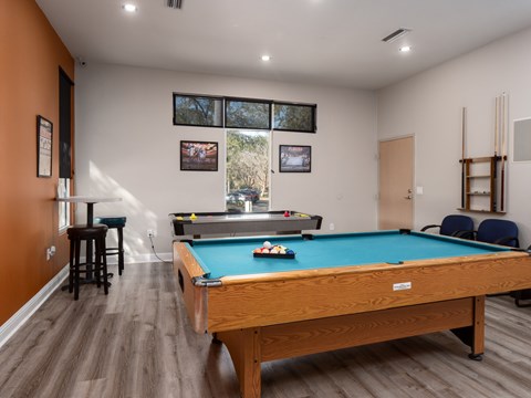 room with a pool table and a bar in the corner